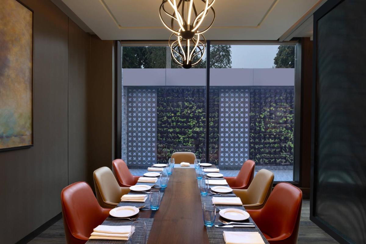 a long dining room with a long table and chairs at Courtyard by Marriott Amritsar in Amritsar