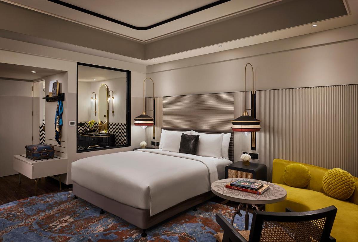 a bedroom with a large white bed and a yellow couch at Hyatt Centric Sector17 Chandigarh in Chandīgarh