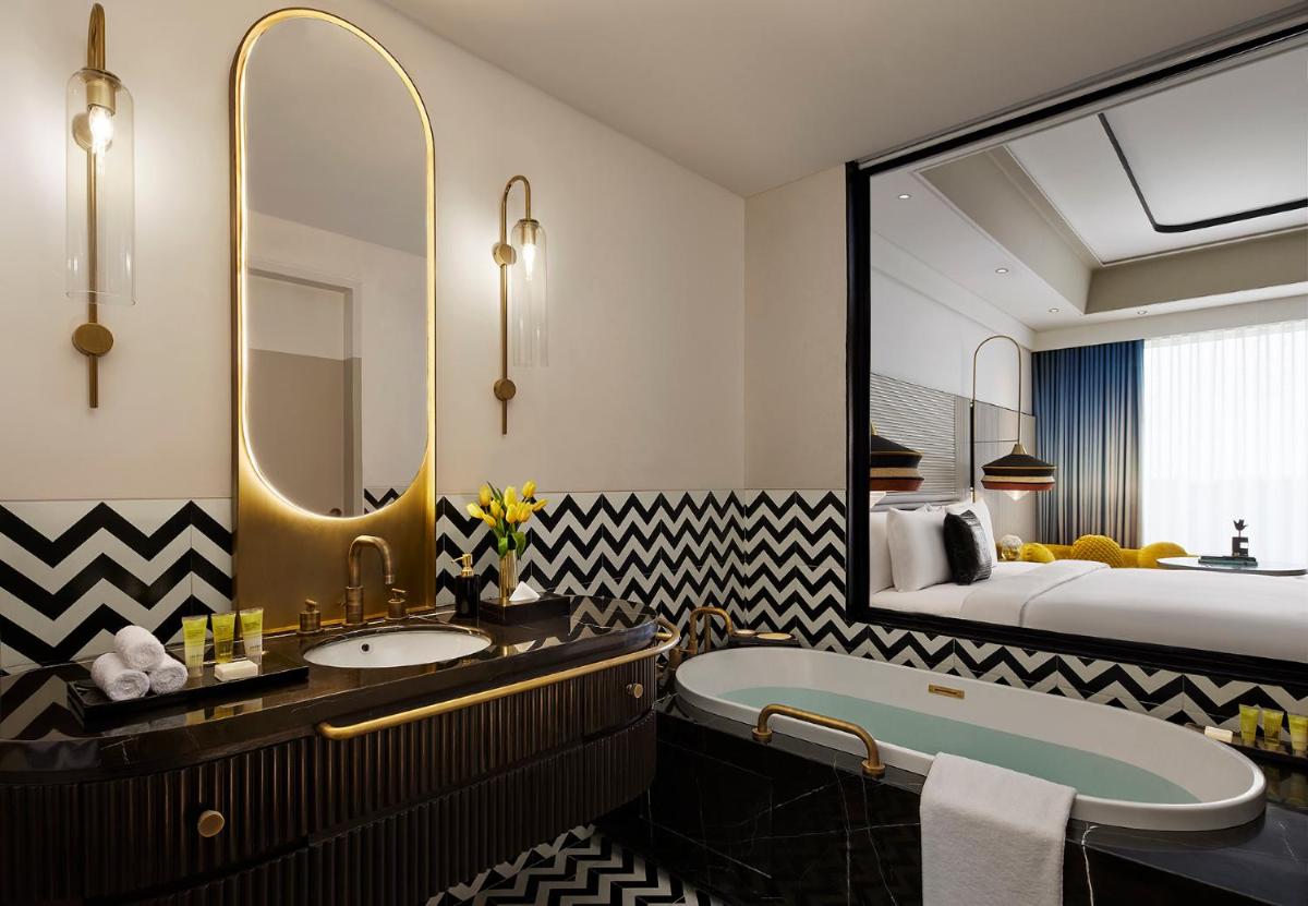 a bathroom with a tub and a sink and a bed at Hyatt Centric Sector17 Chandigarh in Chandīgarh