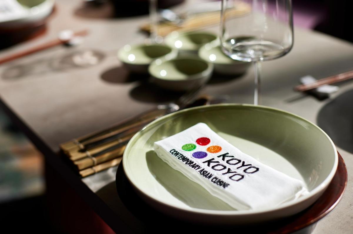 a green bowl on a table with a wine glass at Hyatt Centric Sector17 Chandigarh in Chandīgarh