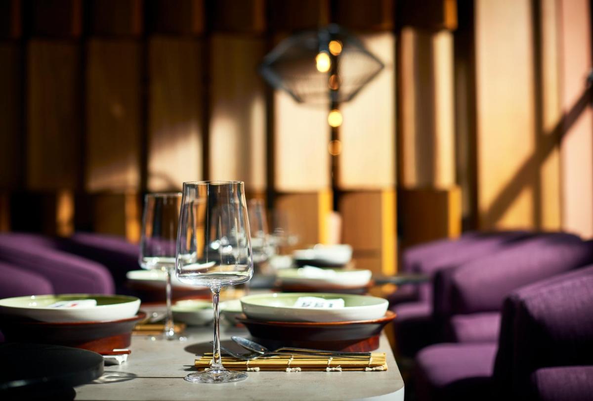 a table with wine glasses and plates on it at Hyatt Centric Sector17 Chandigarh in Chandīgarh