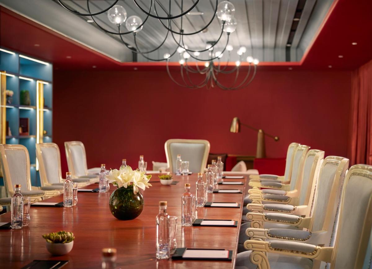 a long table with white chairs and a chandelier at Hyatt Centric Sector17 Chandigarh in Chandīgarh