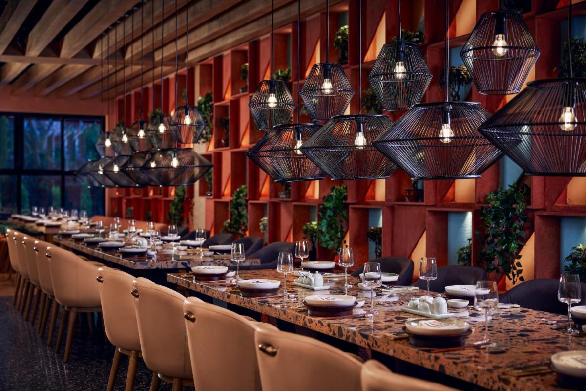 a long table in a room with chairs and lights at Hyatt Centric Sector17 Chandigarh in Chandīgarh