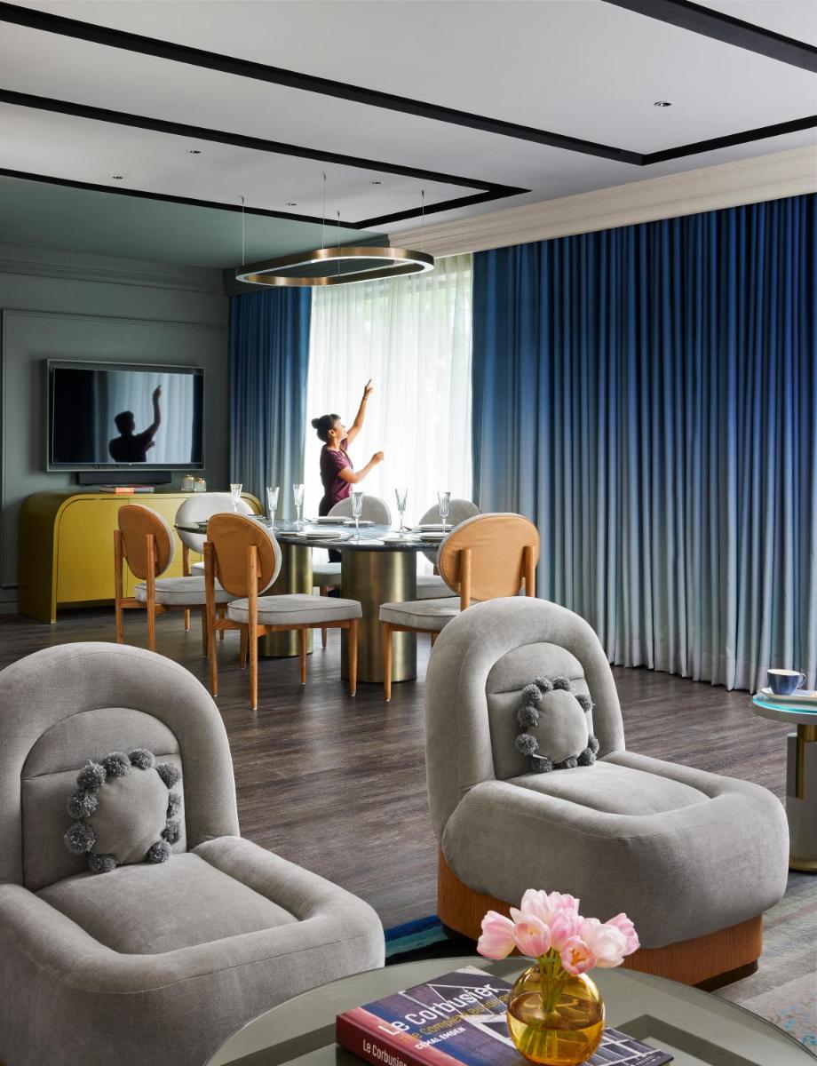 a woman in a room with chairs and a table at Hyatt Centric Sector17 Chandigarh in Chandīgarh