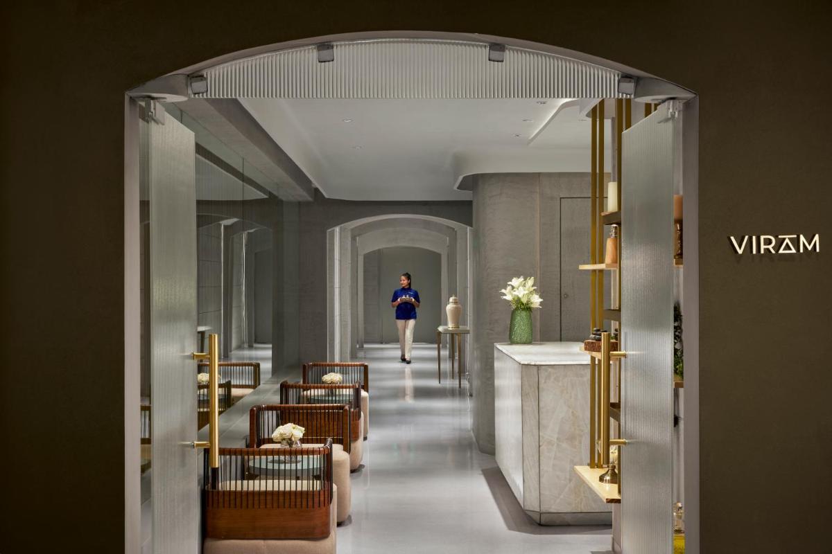 a woman walking down a hallway in a building at Hyatt Centric Sector17 Chandigarh in Chandīgarh