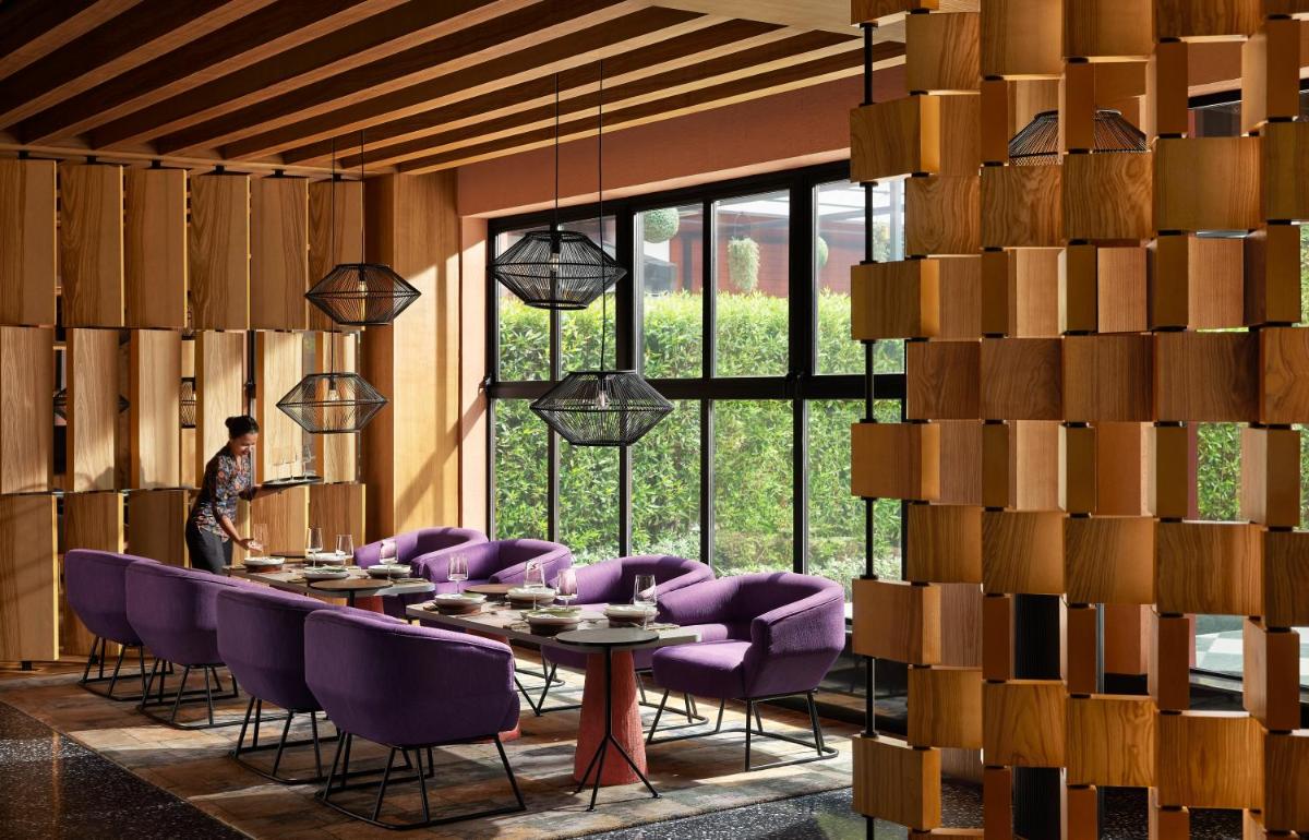 a dining room with purple chairs and a table at Hyatt Centric Sector17 Chandigarh in Chandīgarh