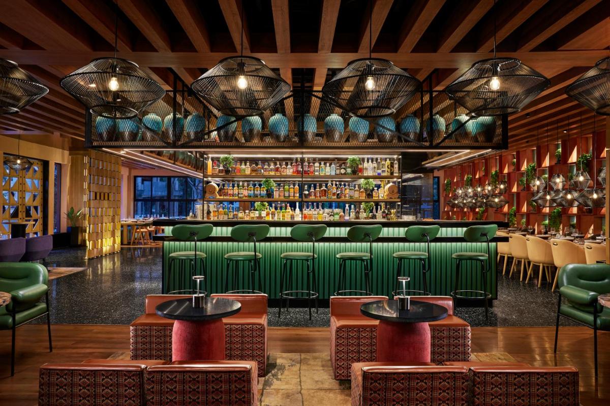 a bar with green chairs and a green bar at Hyatt Centric Sector17 Chandigarh in Chandīgarh