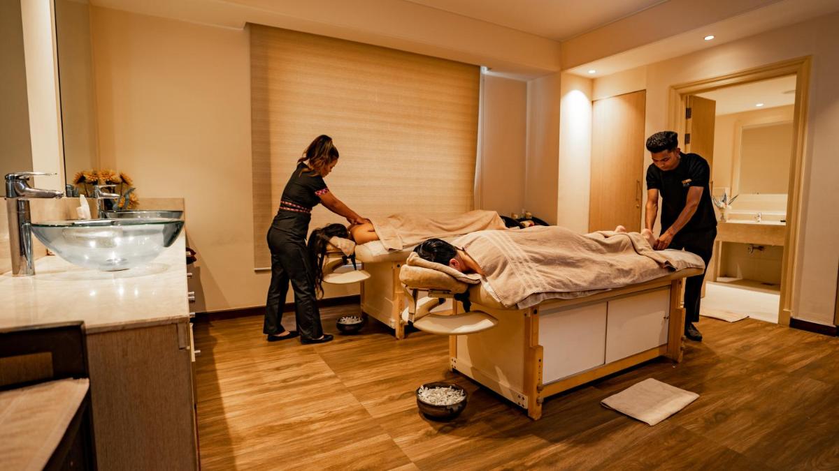 a couple of people in a room with a bed at DoubleTree by Hilton Agra in Agra
