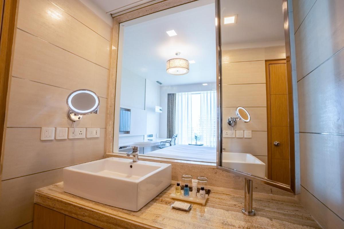 a bathroom with a sink and a large mirror at Radisson Blu Pune Hinjawadi in Pune a bathroom with a sink and a large mirror at Radisson Blu Pune Hinjawadi in Pune