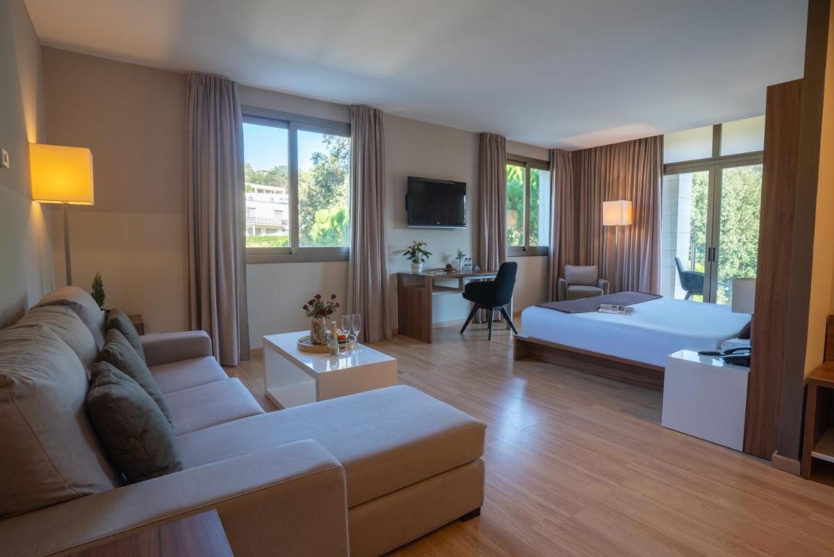 sala de estar amplia con sofá y cama en Hotel & Spa Golden Barcelona, en Vallromanes