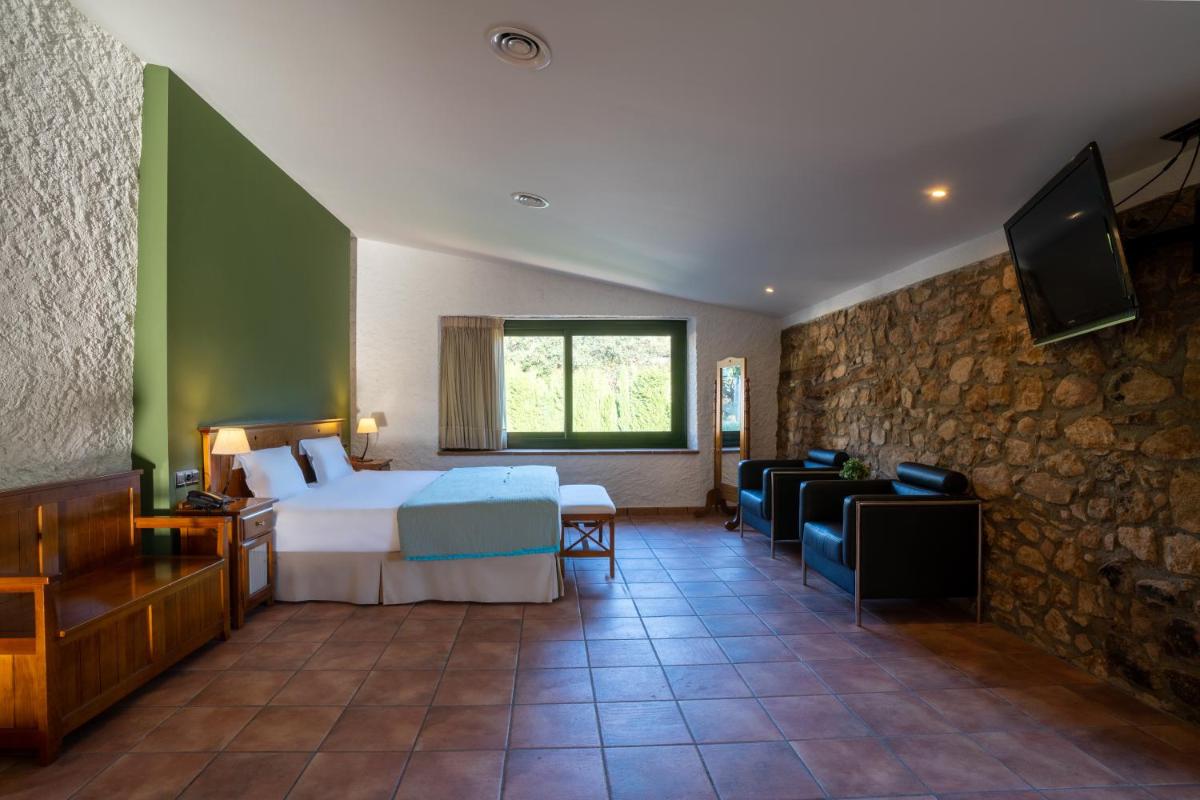 Un dormitorio con una cama y una pared de piedra. en Hotel & Spa Golden Barcelona, en Vallromanes 58 fotos más