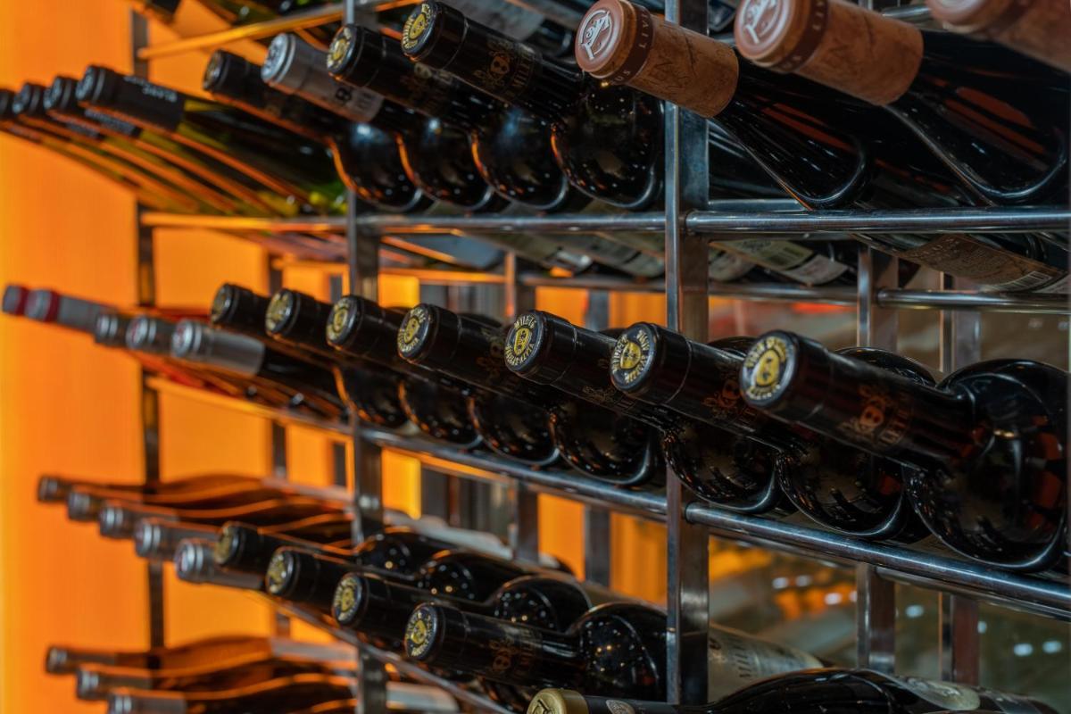 un montón de botellas de vino en un estante en Hotel & Spa Golden Barcelona, en Vallromanes