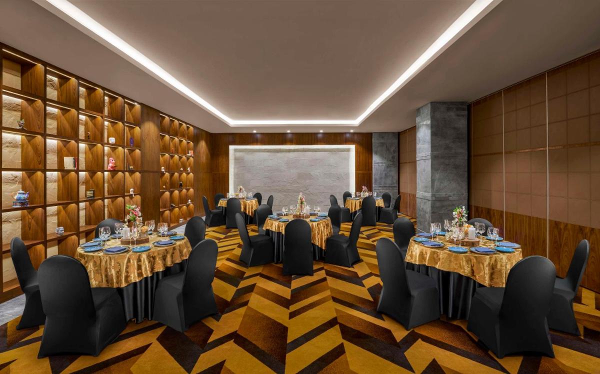 a boardroom with tables and chairs in a room at Hyatt Centric Janakpuri New Delhi in New Delhi