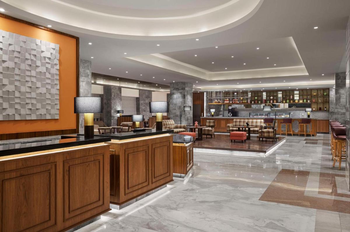 a hotel lobby with a bar and a restaurant at Hyatt Centric Janakpuri New Delhi in New Delhi