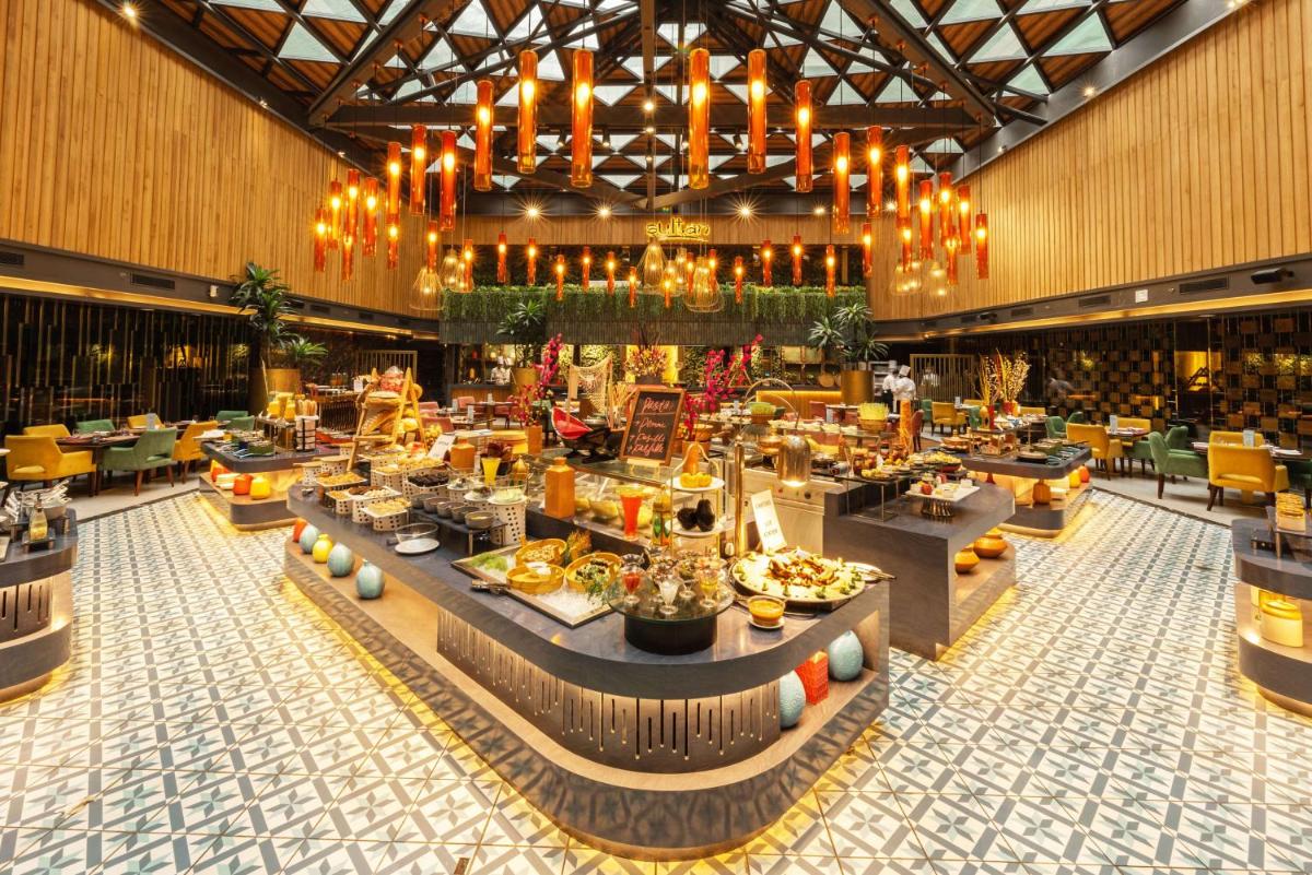 a restaurant with tables and chairs in a building at Radisson Blu Kaushambi Delhi NCR in Ghaziabad