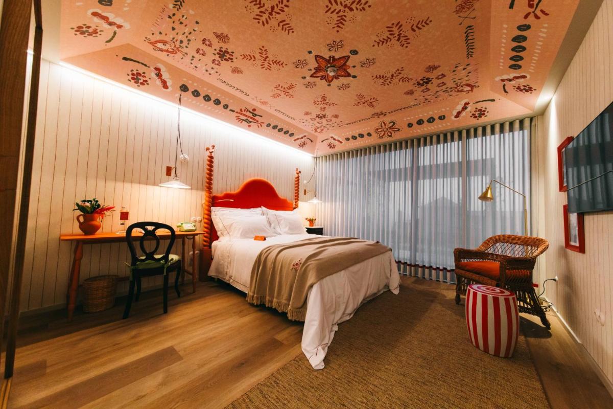 um quarto com uma cama, uma mesa e uma cadeira em Solar de Vila Meã em Barcelos mais 38 fotografias