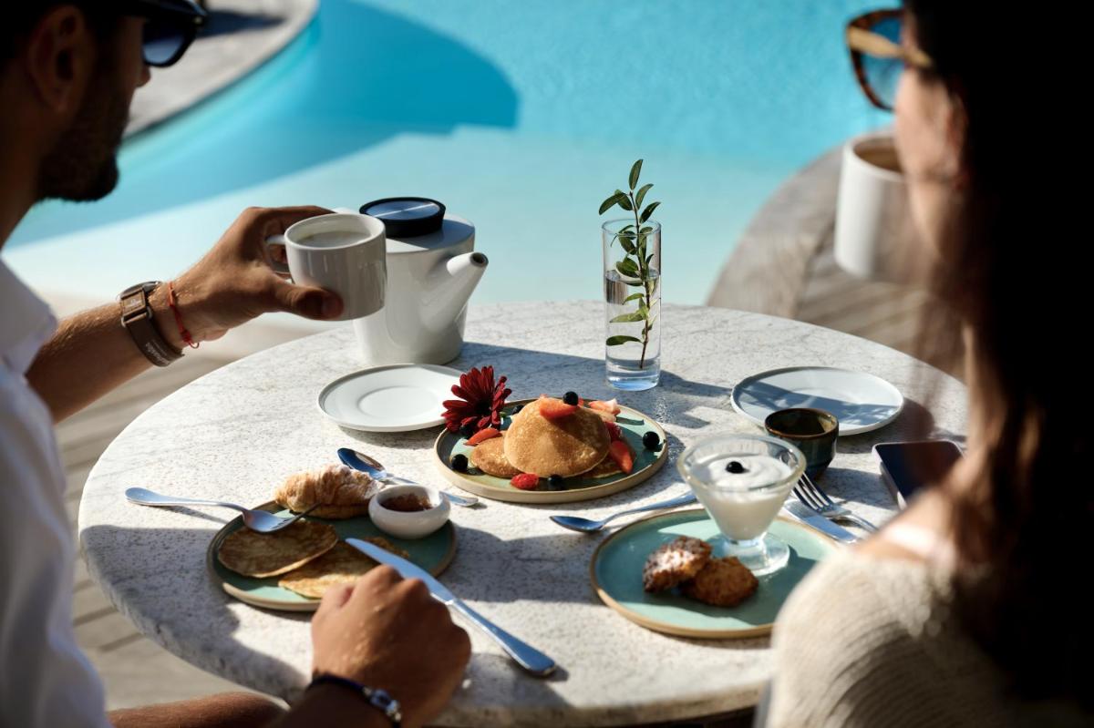 un groupe de personnes assises à une table en train de manger dans l'établissement Hôtel Cala di Greco, à Bonifacio