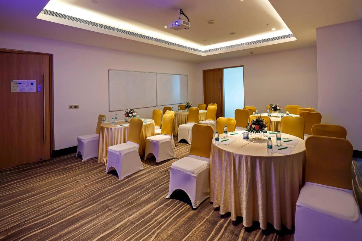 a conference room with tables and chairs and a whiteboard at Holiday Inn Chennai OMR IT Expressway by IHG in Chennai