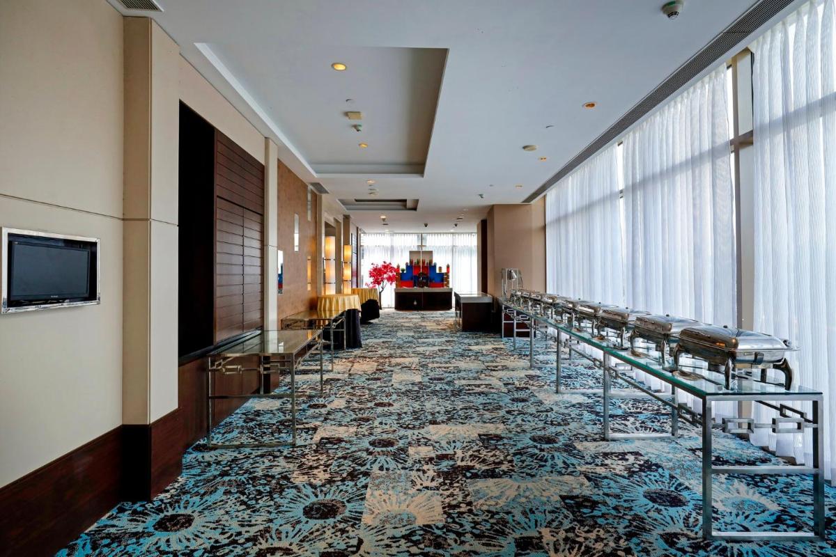 a hallway in a hotel with chairs and a carpet at Holiday Inn Chennai OMR IT Expressway by IHG in Chennai