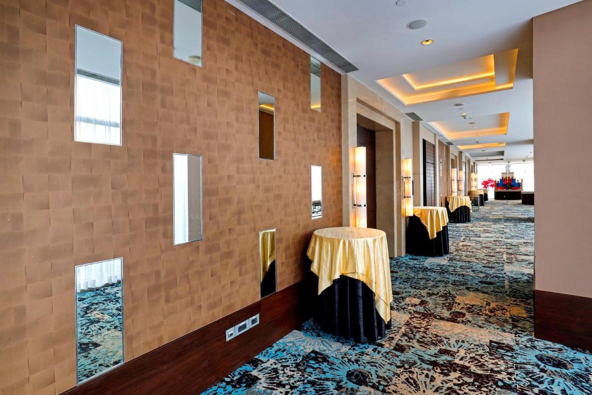 a hallway with two tables with gold table skirts at Holiday Inn Chennai OMR IT Expressway by IHG in Chennai