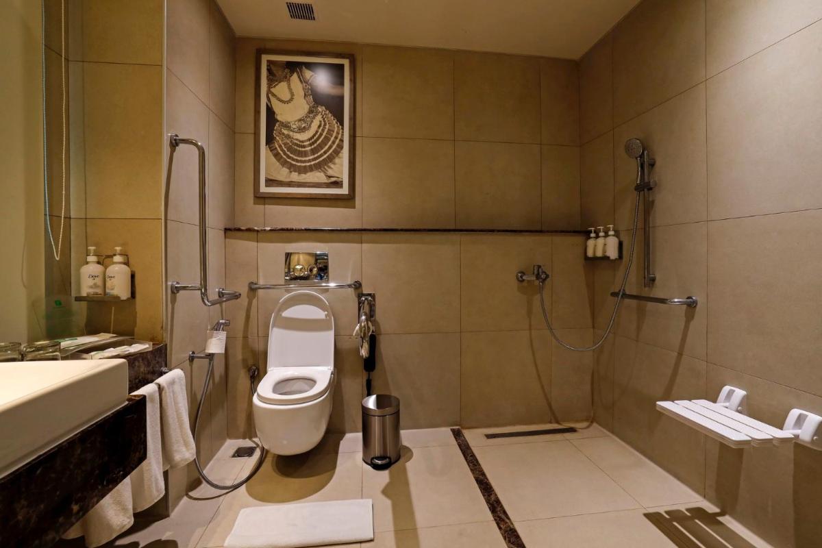 a bathroom with a toilet and a shower and a sink at Holiday Inn Chennai OMR IT Expressway by IHG in Chennai