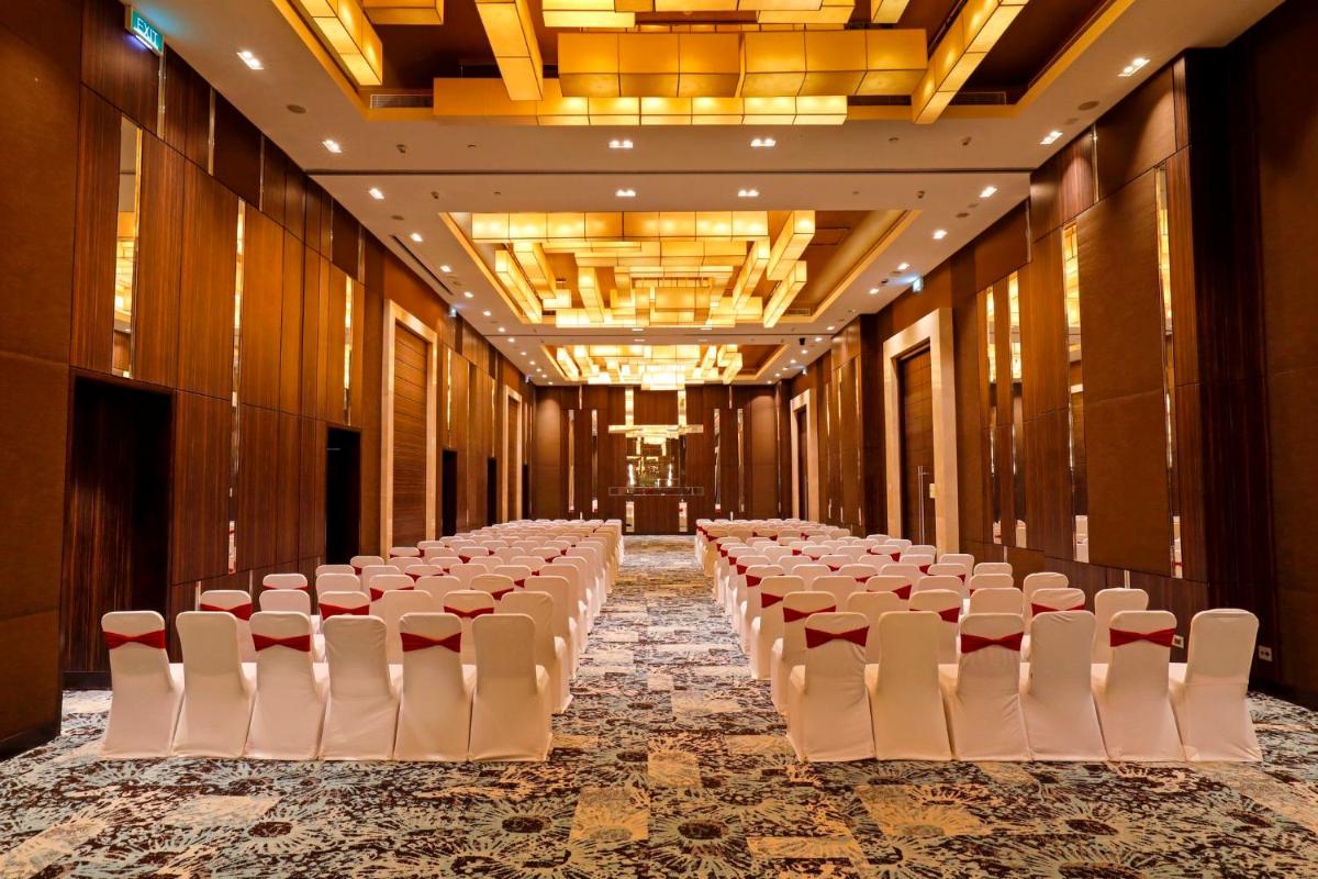 a row of tables and chairs in a banquet hall at Holiday Inn Chennai OMR IT Expressway by IHG in Chennai