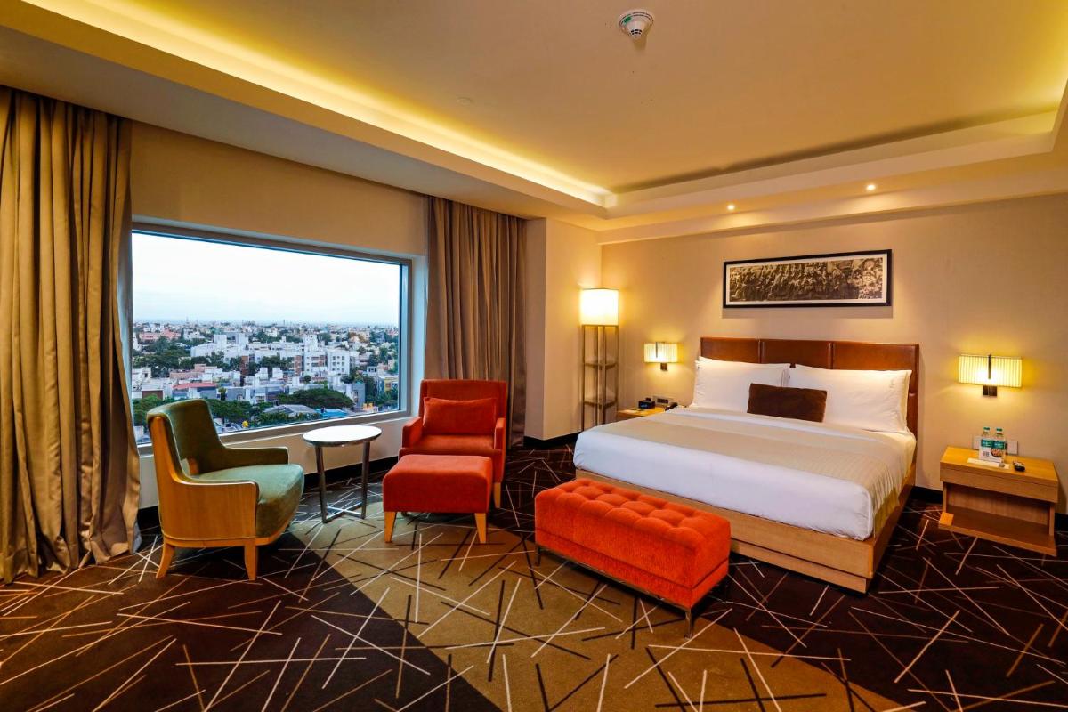a hotel room with a bed and a large window at Holiday Inn Chennai OMR IT Expressway by IHG in Chennai