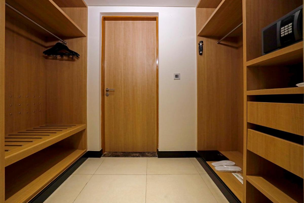 a walk in closet with wooden cabinets and a door at Holiday Inn Chennai OMR IT Expressway by IHG in Chennai