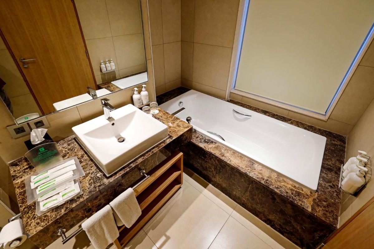 a bathroom with a sink and a bath tub at Holiday Inn Chennai OMR IT Expressway by IHG in Chennai