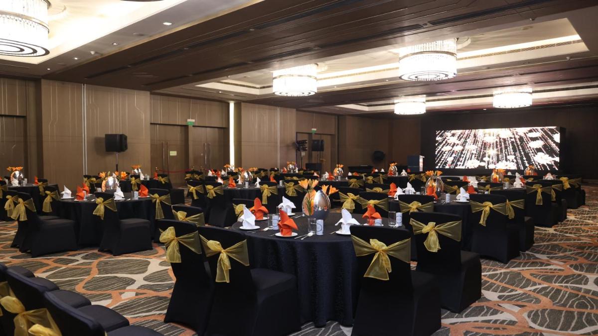 a banquet hall with black tables with yellow bows at Holiday Inn New Delhi Aerocity by IHG in New Delhi