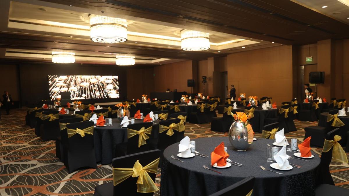 a banquet hall with black tables with yellow bows at Holiday Inn New Delhi Aerocity by IHG in New Delhi