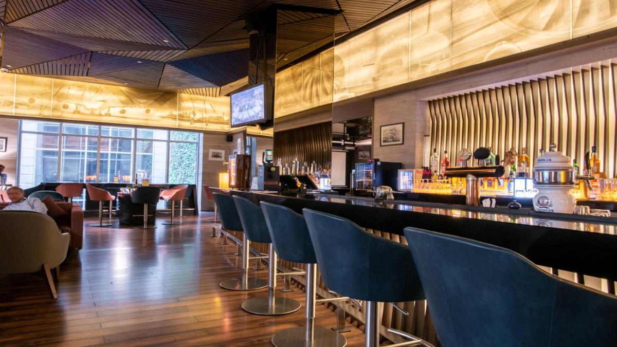 a bar with blue chairs in a restaurant at Holiday Inn New Delhi Aerocity by IHG in New Delhi