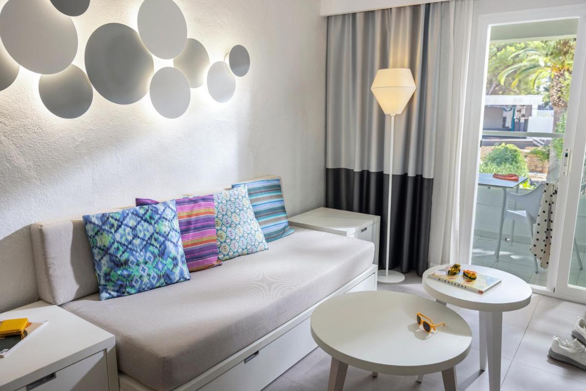 una sala de estar con un sofá y una mesa en TUI MAGIC LIFE Cala Pada - All Inclusive, en Santa Eulària des Riu