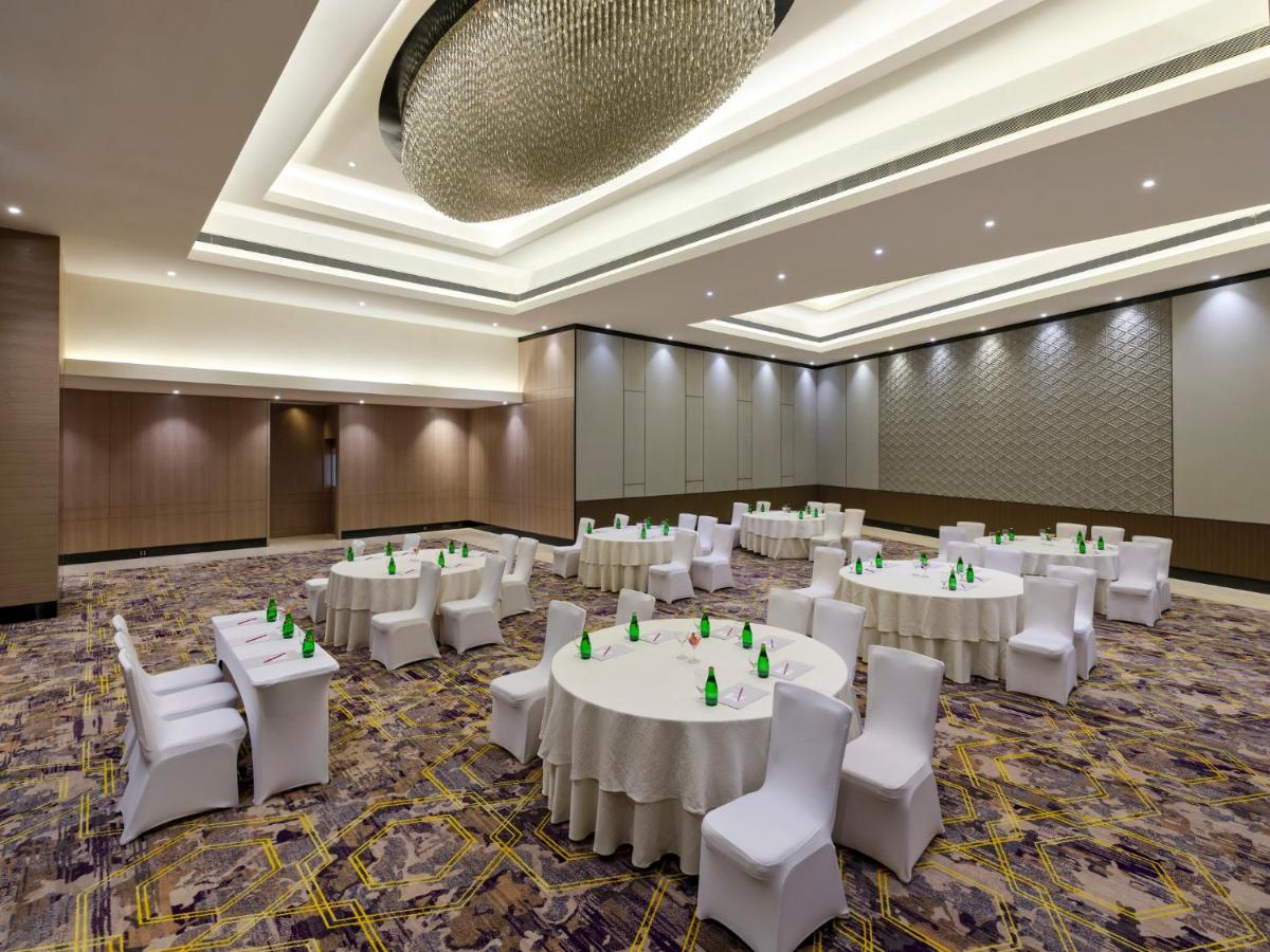 a banquet hall with white tables and white chairs at Crowne Plaza Ahmedabad City Centre by IHG in Ahmedabad