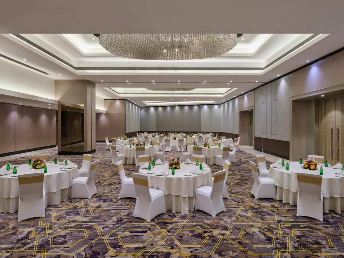 a banquet hall with white tables and white chairs at Crowne Plaza Ahmedabad City Centre by IHG in Ahmedabad +86 photos