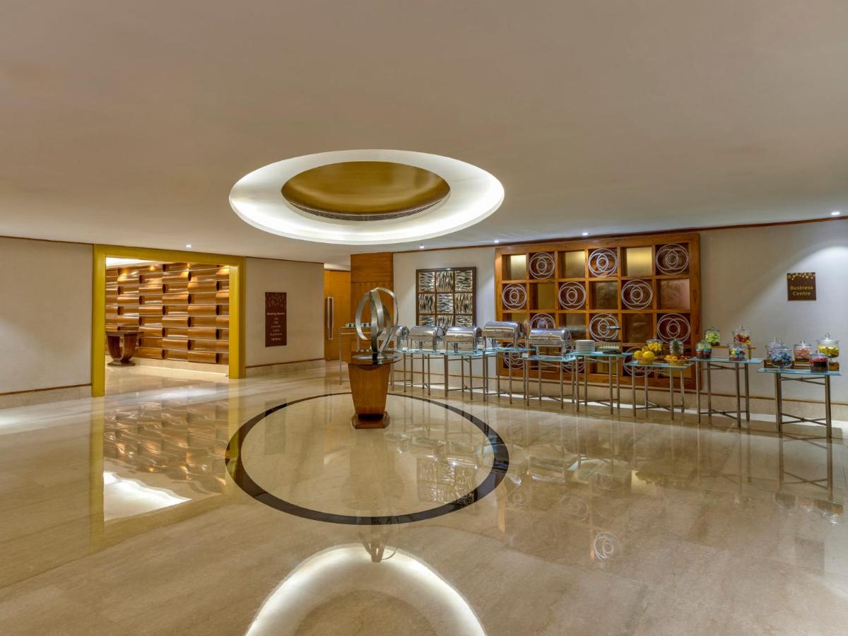 a lobby with a glass table and a wine cellar at Crowne Plaza Ahmedabad City Centre by IHG in Ahmedabad