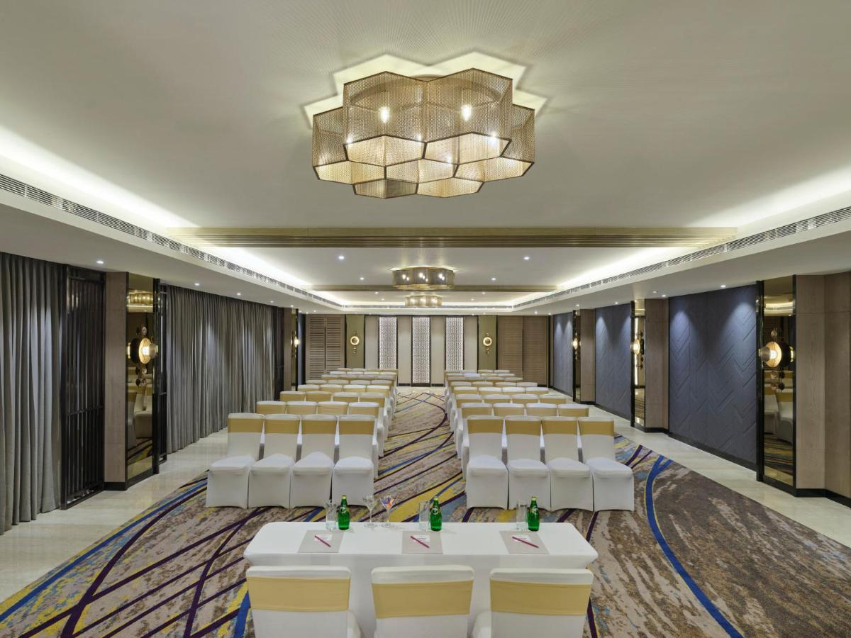 a conference room with white chairs and a chandelier at Crowne Plaza Ahmedabad City Centre by IHG in Ahmedabad