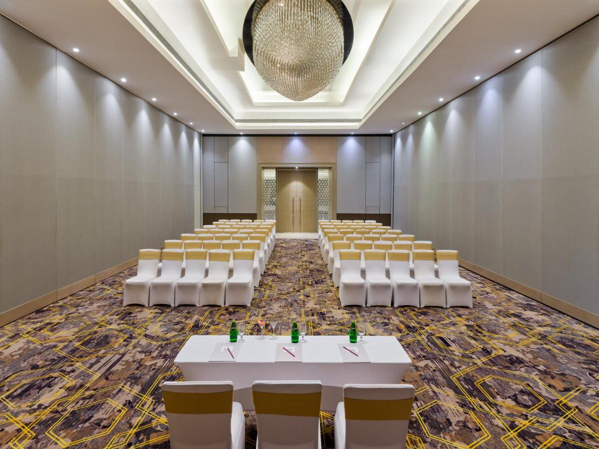 an empty room with rows of tables and chairs at Crowne Plaza Ahmedabad City Centre by IHG in Ahmedabad