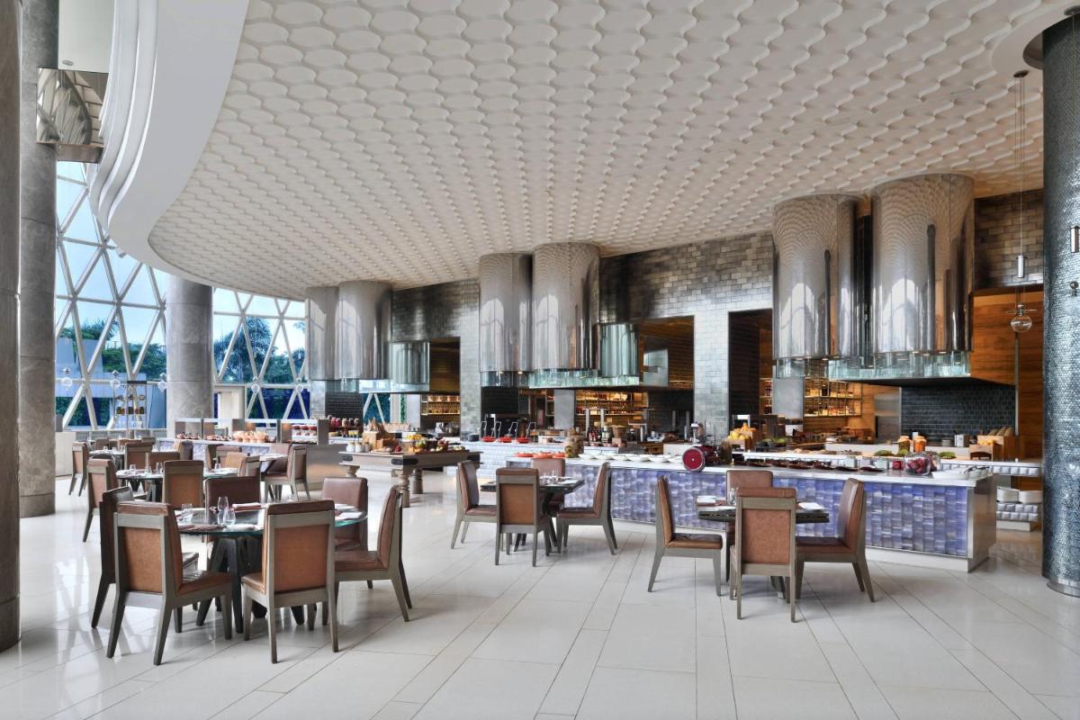 a restaurant with tables and chairs in a building at JW Marriott Hotel Kolkata in Kolkata