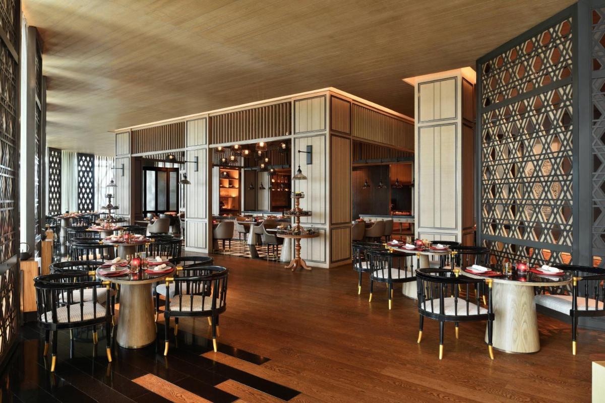 a restaurant with tables and chairs in a room at JW Marriott Hotel Kolkata in Kolkata