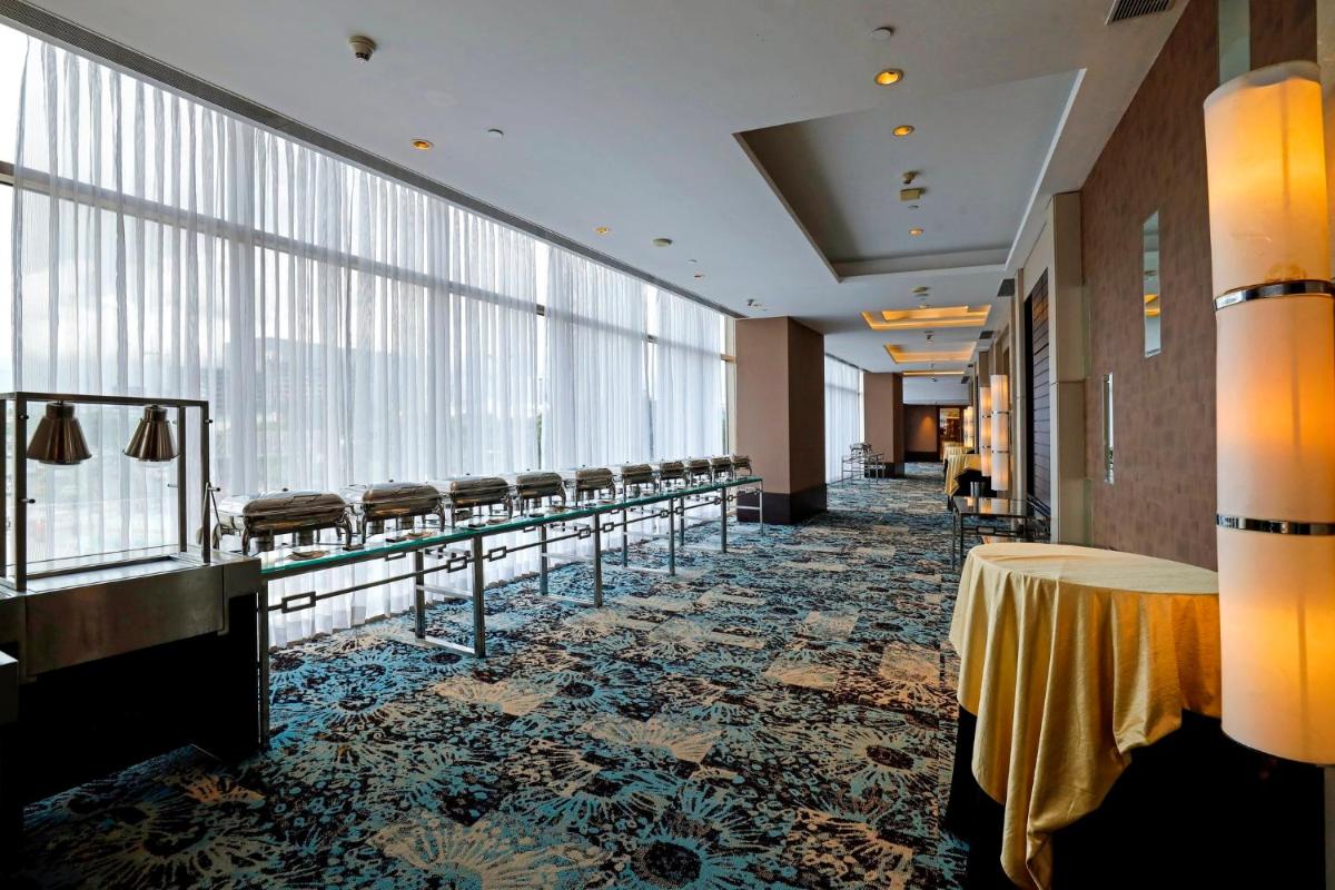 a conference room with a table and chairs and windows at Holiday Inn Chennai OMR IT Expressway by IHG in Chennai