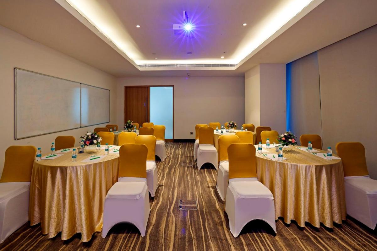 a conference room with tables and chairs and a whiteboard at Holiday Inn Chennai OMR IT Expressway by IHG in Chennai