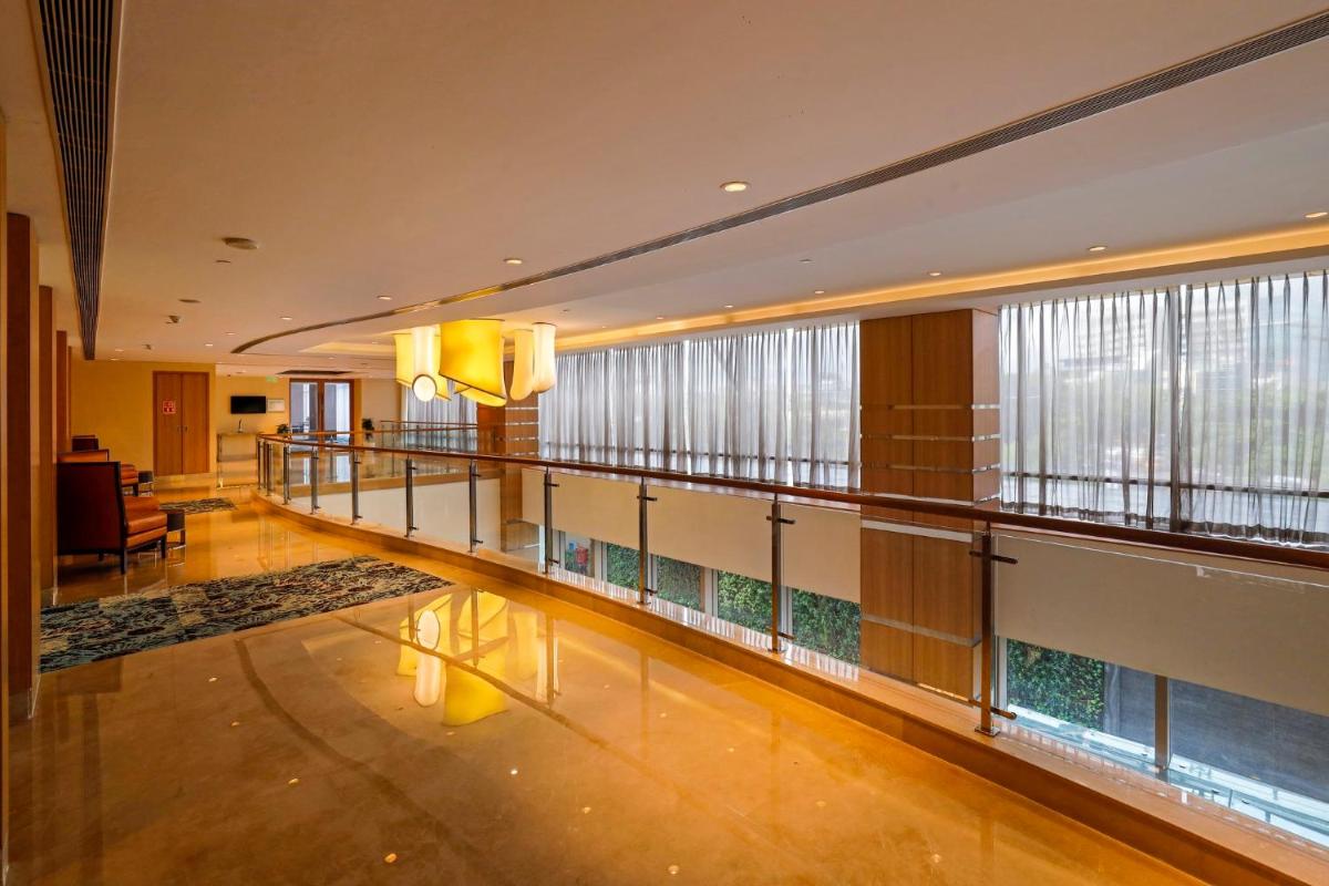 a large lobby with a balcony withwindows and a floor at Holiday Inn Chennai OMR IT Expressway by IHG in Chennai