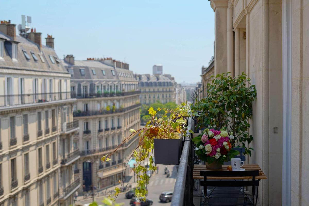 un balcon avec des fleurs et des plantes dans une rue de la ville dans l'établissement Hotel Litteraire Le Swann, BW Premier Collection, à Paris