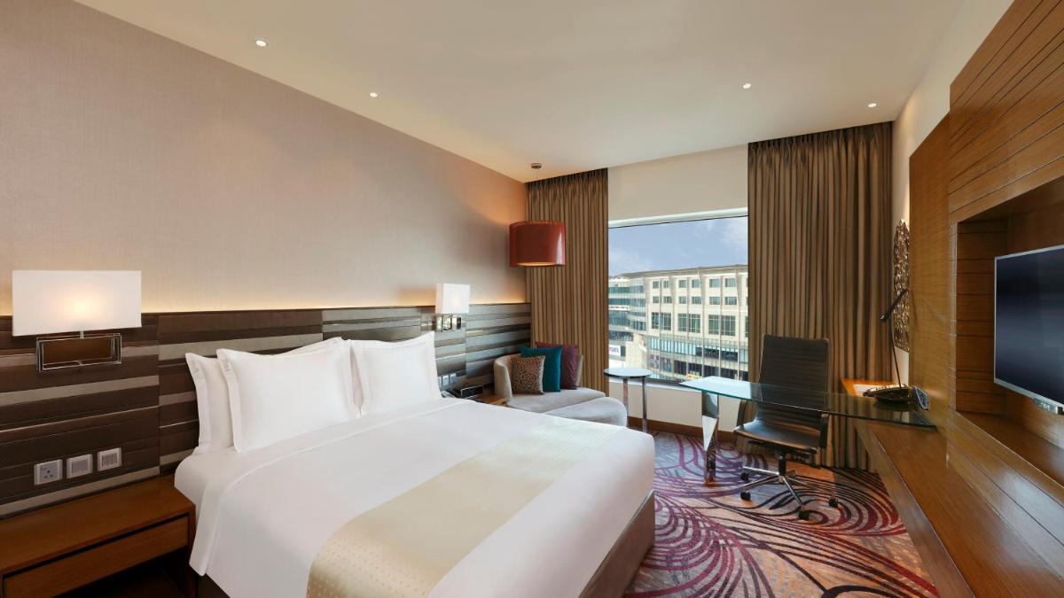 a hotel room with a bed and a television at Holiday Inn Jaipur City Centre by IHG in Jaipur a hotel room with a bed and a television at Holiday Inn Jaipur City Centre by IHG in Jaipur