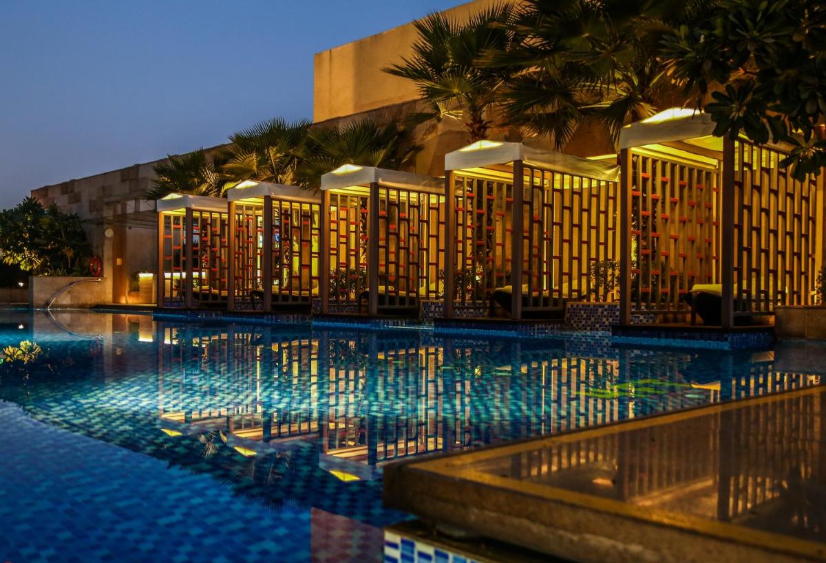 a swimming pool in front of a hotel at night at Taj City Centre Gurugram in Gurgaon