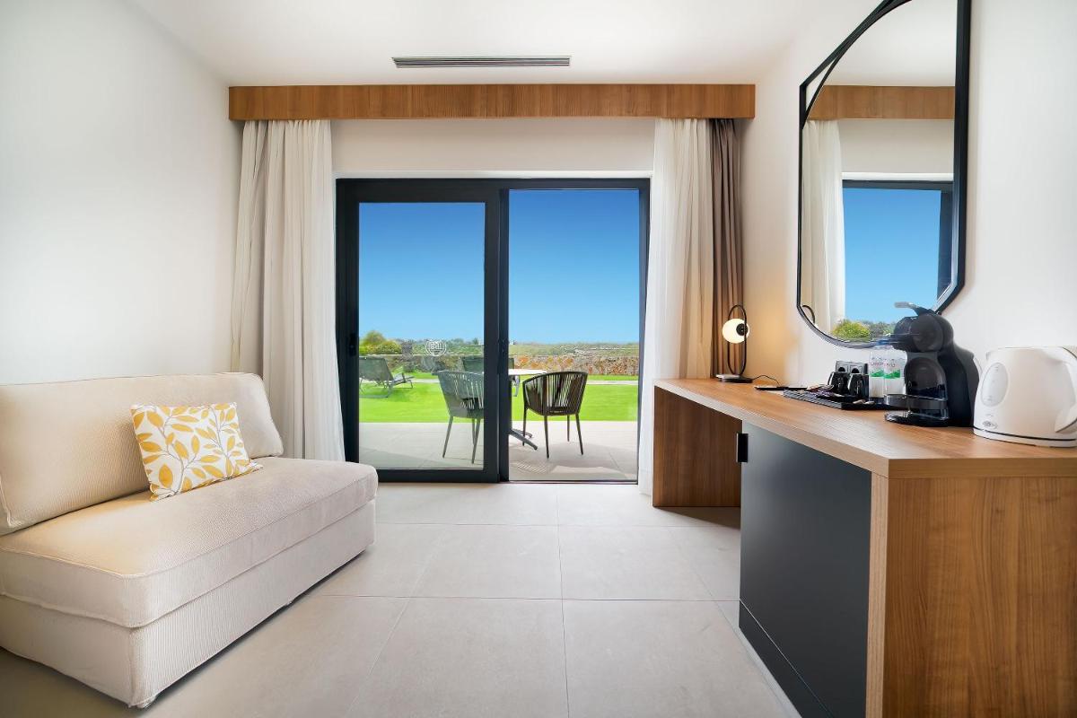 Una sala de estar con un sofá, una silla y una mesa. en Bull Vital Suites & Spa Boutique Hotel - Only Adults, en Playa del Inglés