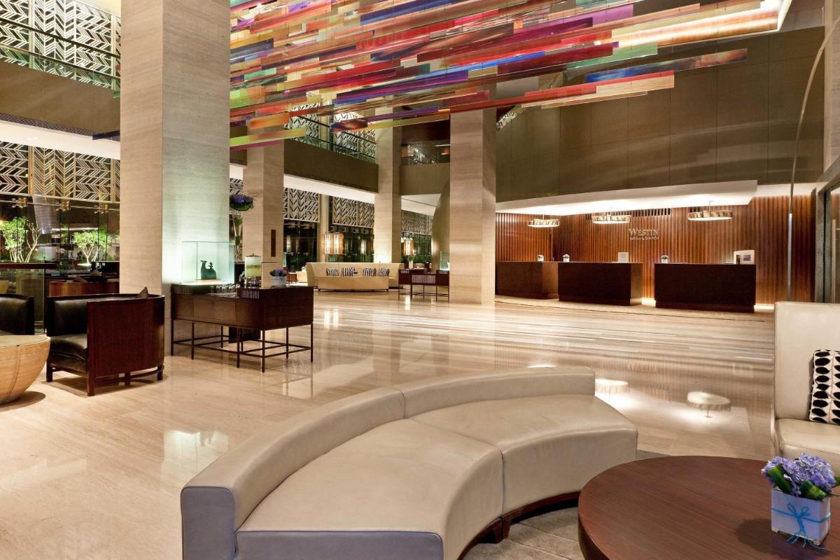 a lobby of a hotel with a couch and tables at The Westin Gurgaon, New Delhi in Gurgaon