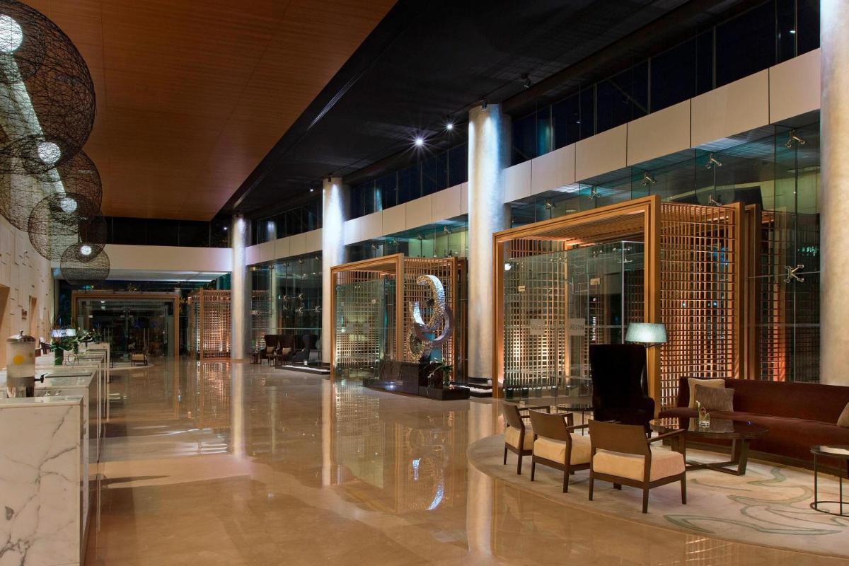 a lobby of a building with tables and chairs at The Westin Mumbai Garden City in Mumbai