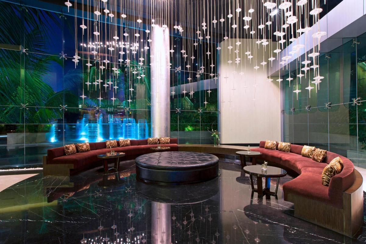 a lobby with couches and tables and a chandelier at The Westin Mumbai Garden City in Mumbai